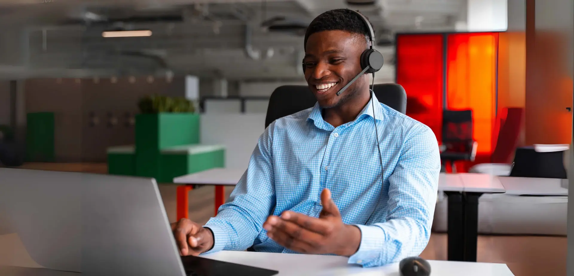 An Adrolly Finance support agent wearing a headset at their desk.